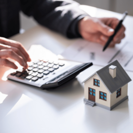 Engenheiro em Ipatinga fazendo regularização imobiliária usando calculadora.